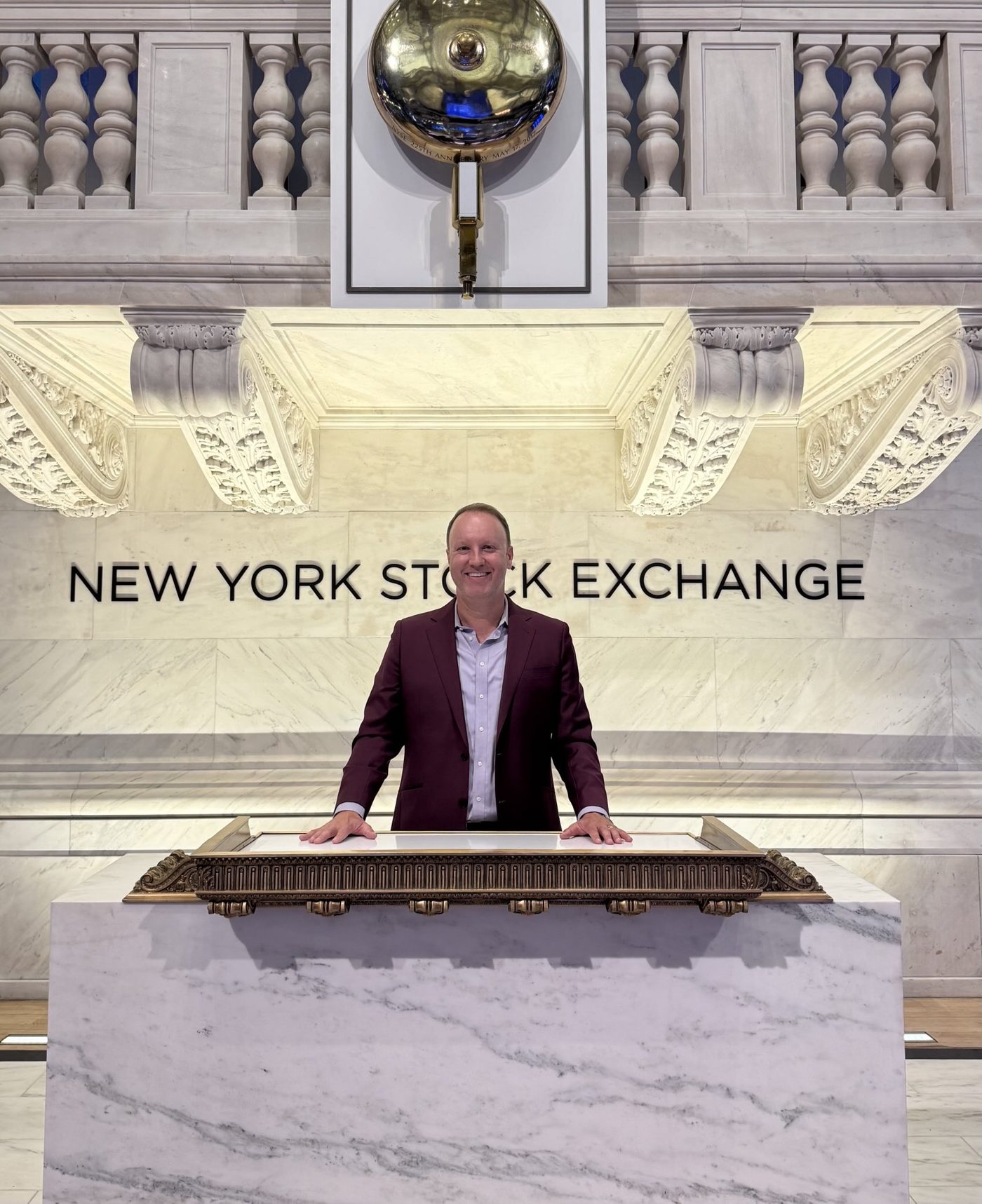 Darren Marble at the podium on the floor of the New York Stock Exchange, beneath the opening bell