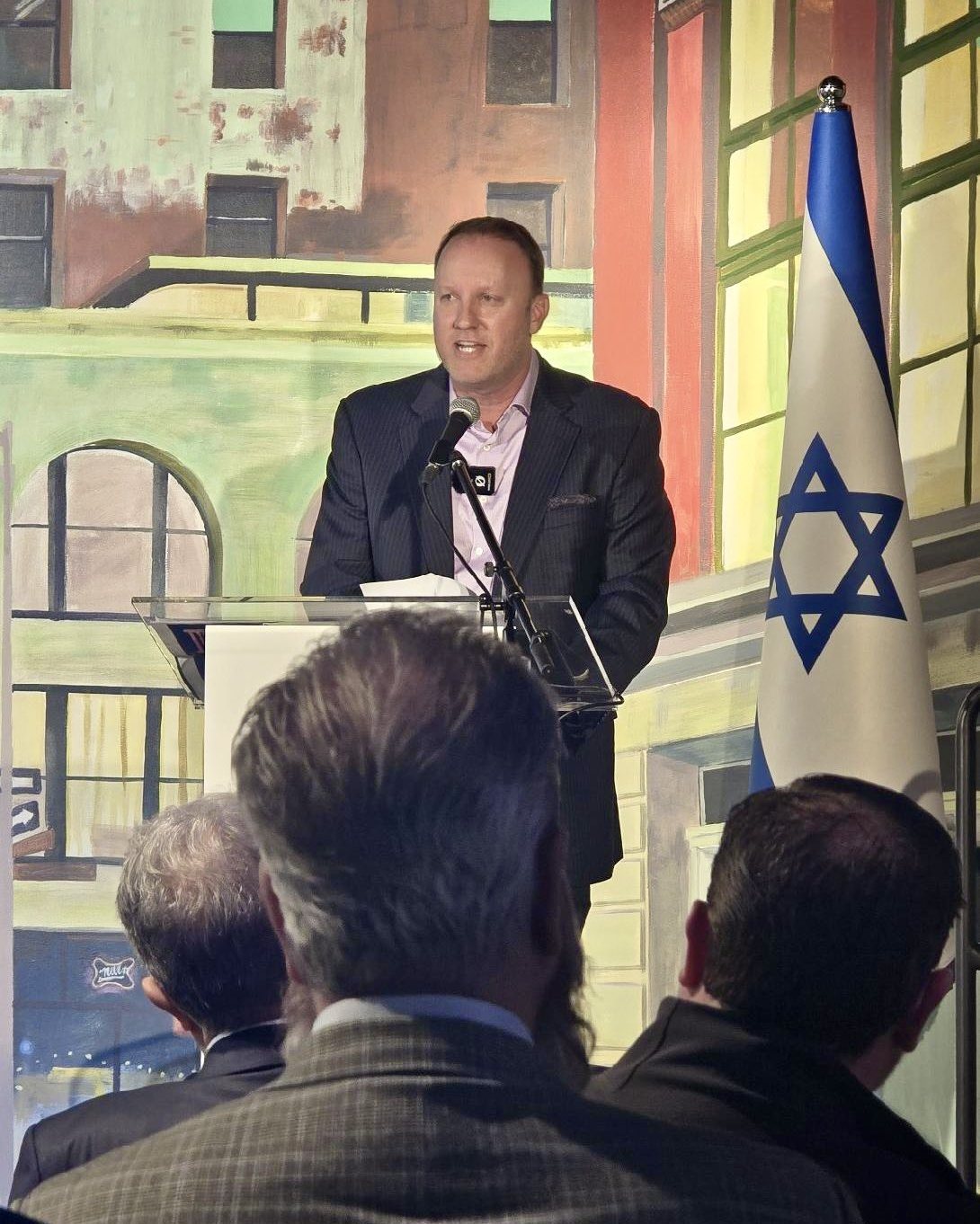 Darren Marble speaking at a podium to a seated audience